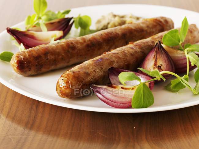 Salsicce arrosto con cipolle rosse — Foto stock