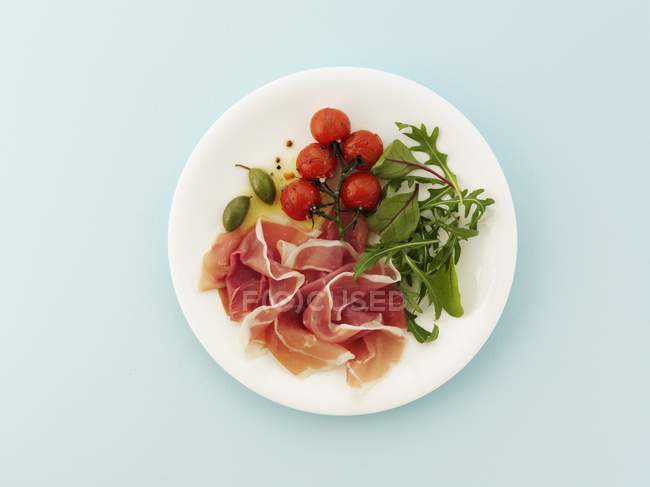 Proscuitto with roast tomatoes — Stock Photo