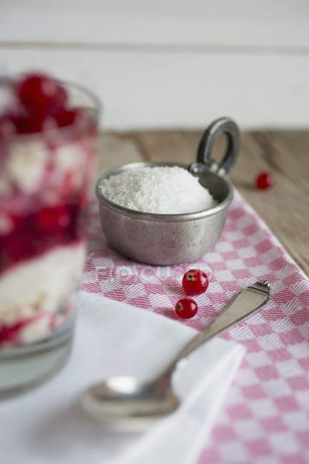 Coconut flakes and redcurrants — Stock Photo