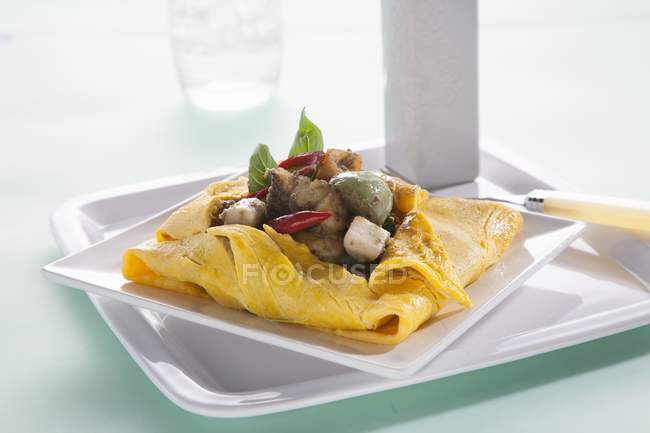 Vista close-up de uma omeleta preenchida com caril de peixe verde — Fotografia de Stock