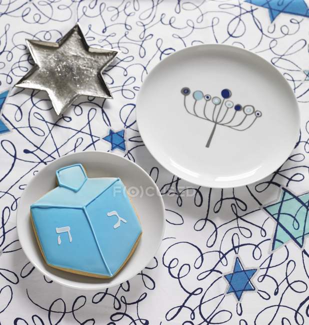 Vista de primer plano de un plato en forma de estrella con un plato y una galleta para Hanukkah - foto de stock