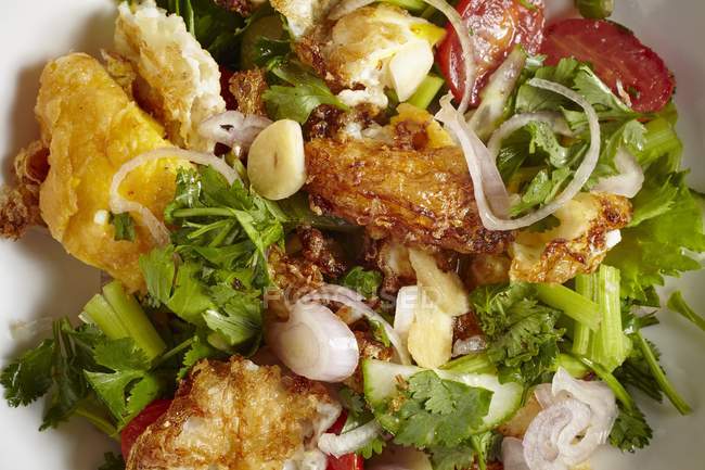 Yam Khai Dao - ensalada de verduras con huevos fritos en plato blanco - foto de stock