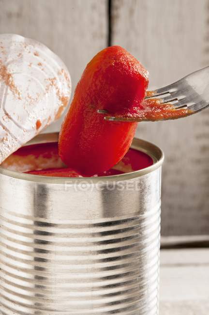 Um tomate a ser tirado de uma lata — Fotografia de Stock