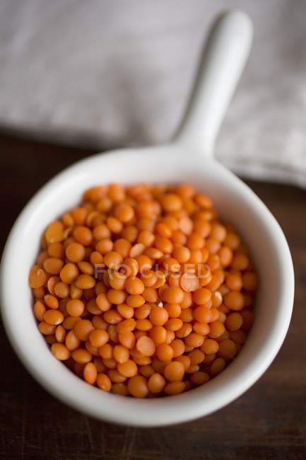 Closeup view of red lentils in a white bowl — Stock Photo