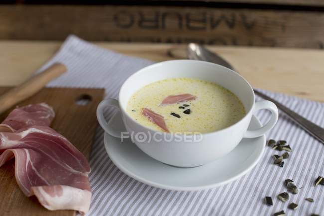 Closeup view of celery soup with ham and pumpkin seeds — Stock Photo