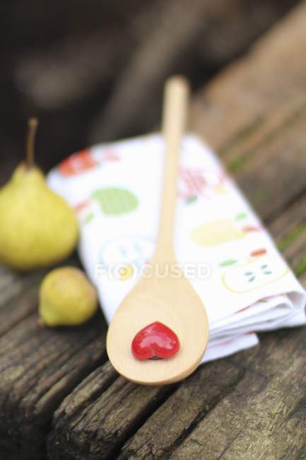 Closeup view of wooden spoon with a heart and two small pears — Stock Photo