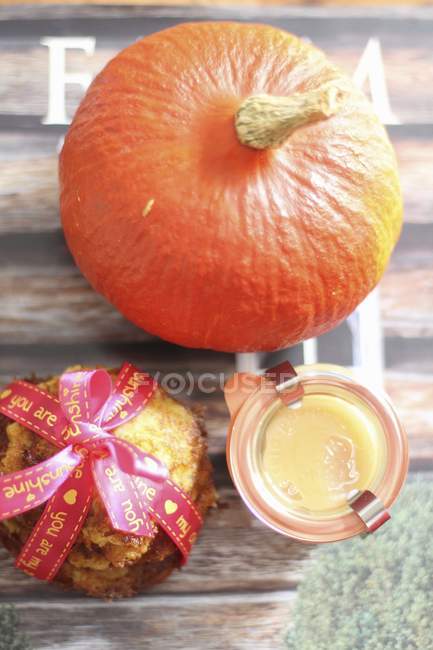 A pumpkin with potato fritters as a gift on wooden surface — Stock Photo