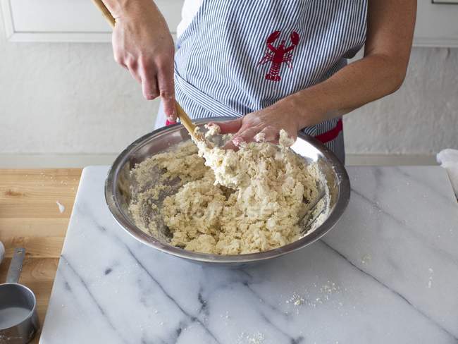 Femme mélangeant la pâte de biscuit au babeurre dans un bol — Photo de stock
