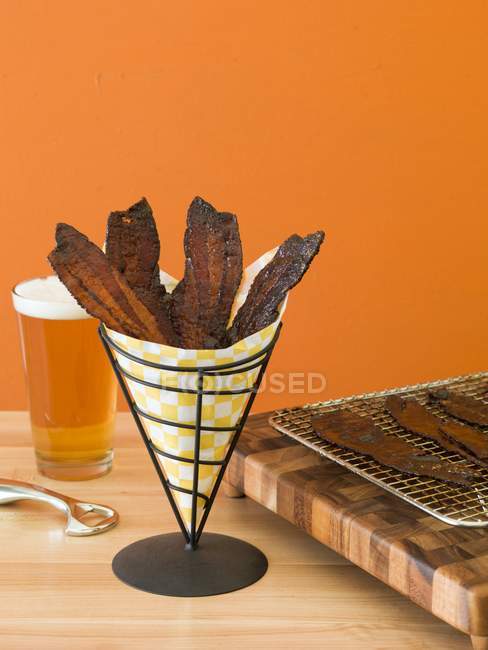 Candied bacon strips in paper cone — Stock Photo