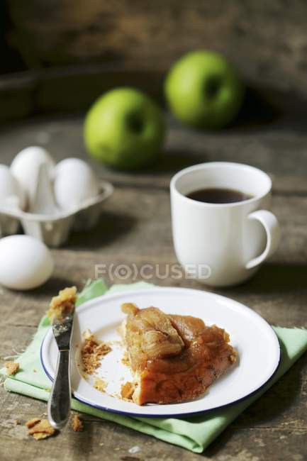 Кусочек тарт-татина на тарелке с вилкой на деревянной поверхности — стоковое фото