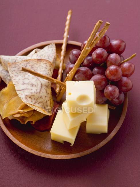 Cubes of cheese with grapes — Stock Photo