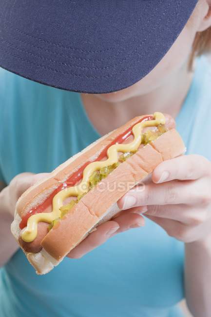 Femme tenant hot dog avec moutarde — Photo de stock
