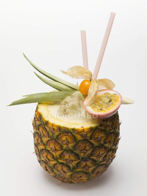 Hollowed-out pineapple with straws — Stock Photo
