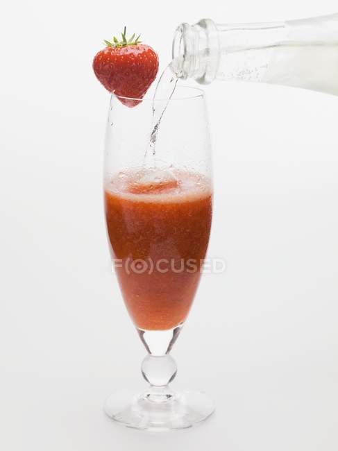 Pouring  Strawberry and sparkling wine cocktail — Stock Photo