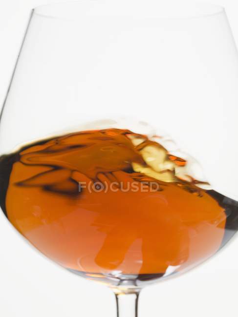 Cognac swirling in a glass — Stock Photo