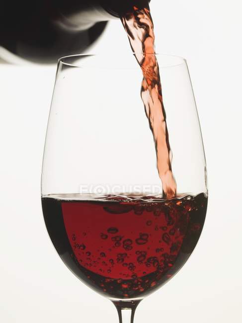 Rotwein ins Glas gegossen — Stockfoto