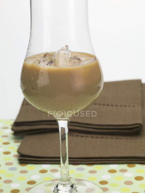 Vue rapprochée de la liqueur de crème avec des glaçons dans un verre — Photo de stock