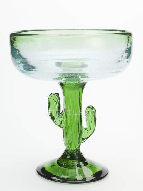 Крупный план зеленого коктейльного стекла в форме кактуса на белой поверхности — стоковое фото