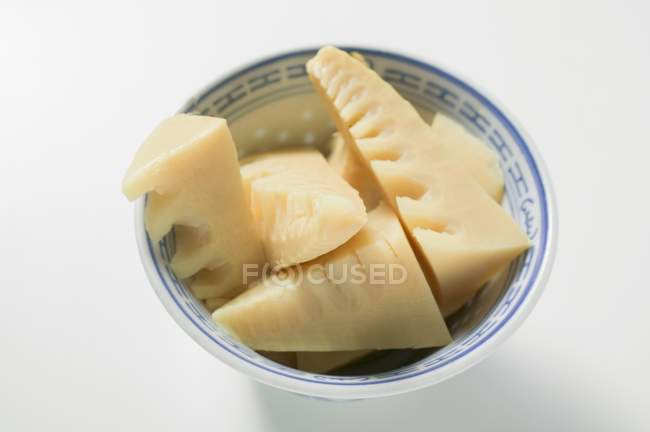 Pousses de bambou dans un bol asiatique sur la surface blanche — Photo de stock