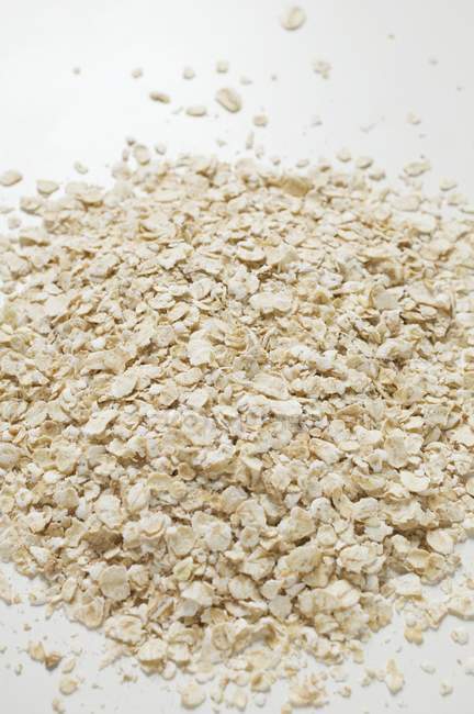 Closeup elevated view of a rolled oats heap on white surface — Stock Photo