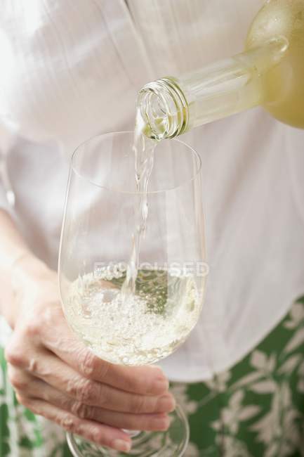 Женщина наливает белое вино — стоковое фото