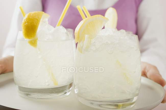 Woman holding tray with lemonade — Stock Photo