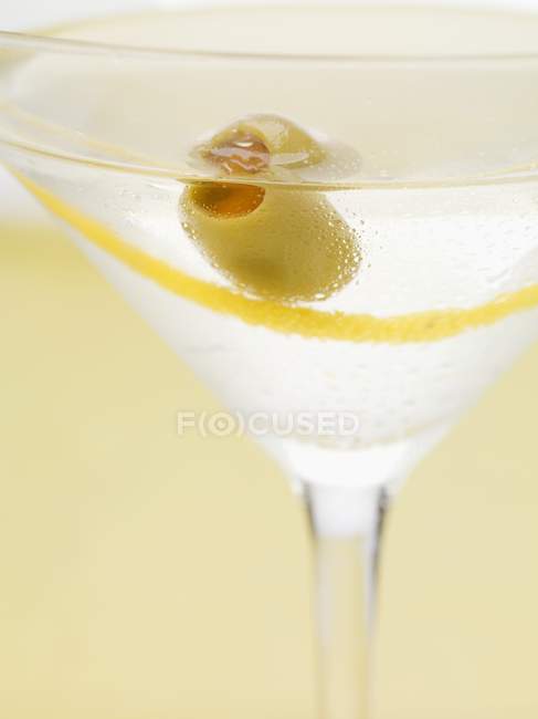 Мартини с оливковой и лимонной цедрой — стоковое фото