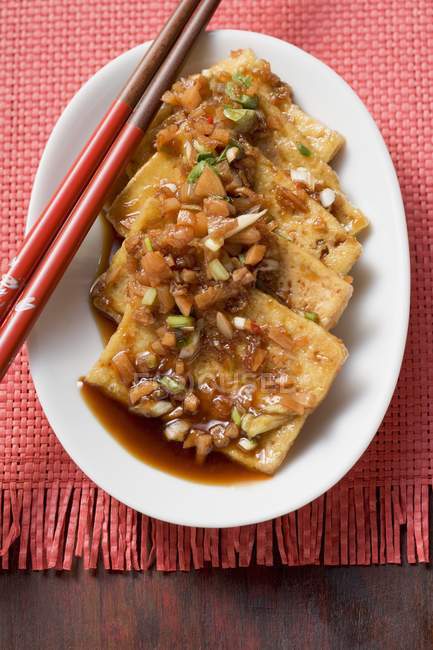 Tofu marinato con aglio su piatto bianco con bastoncini di legno — Foto stock