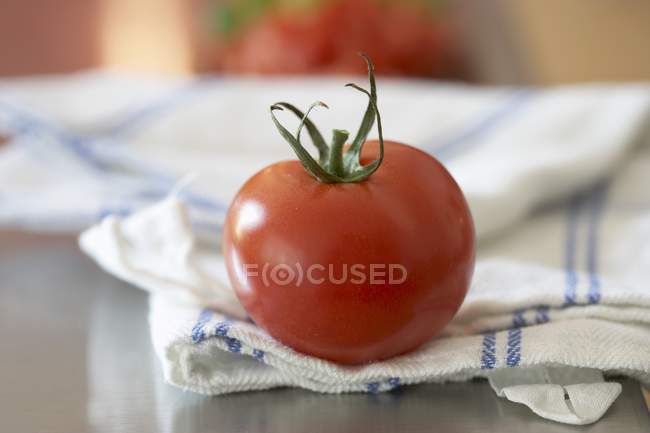 Tomato on tea towel — Stock Photo