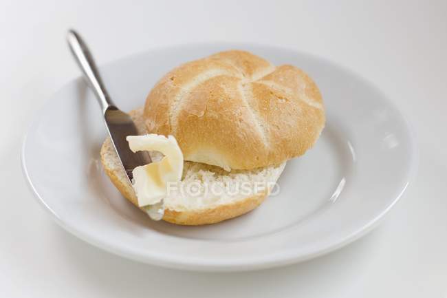 Panecillo con mantequilla - foto de stock