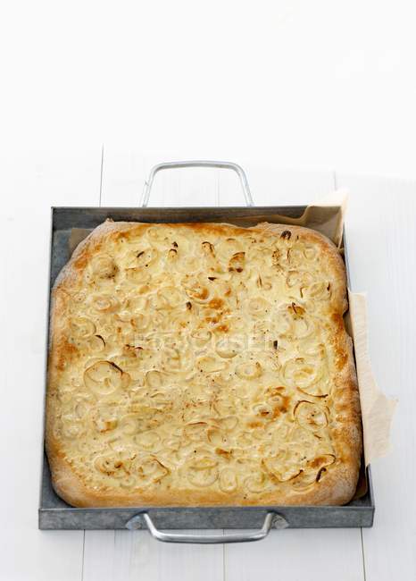 Vue surélevée de la tarte à l'oignon sur la plaque de cuisson — Photo de stock