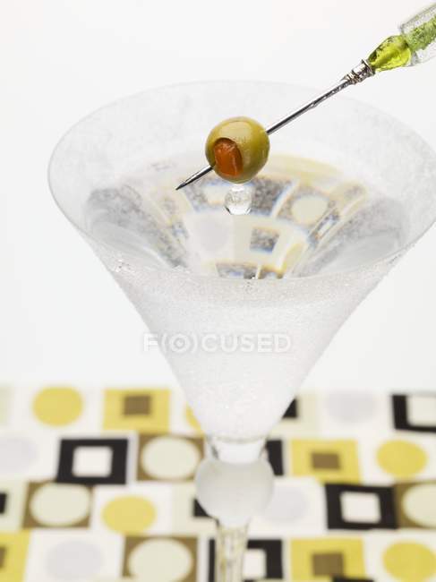 Martini with olive on cocktail stick — Stock Photo