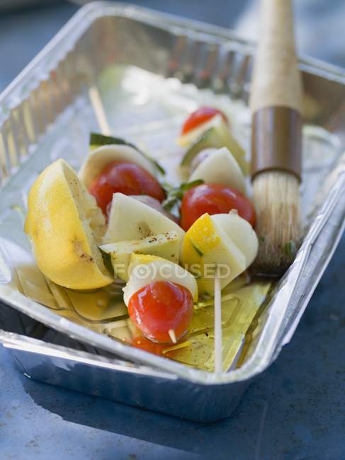 Vegetable kebabs in aluminium dish with oil and brush — Stock Photo