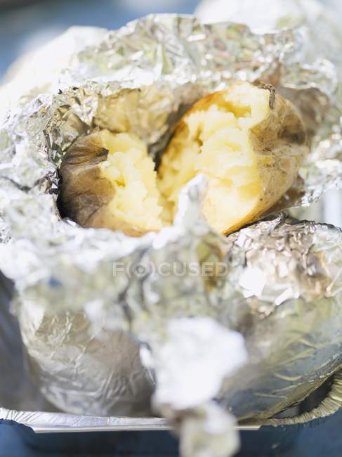 Baked potato in foil — Stock Photo