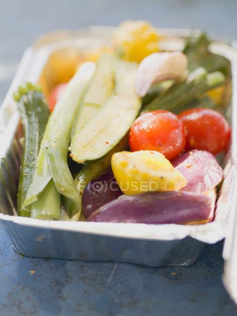 Vegetables in aluminium dish, ready for grilling — Stock Photo