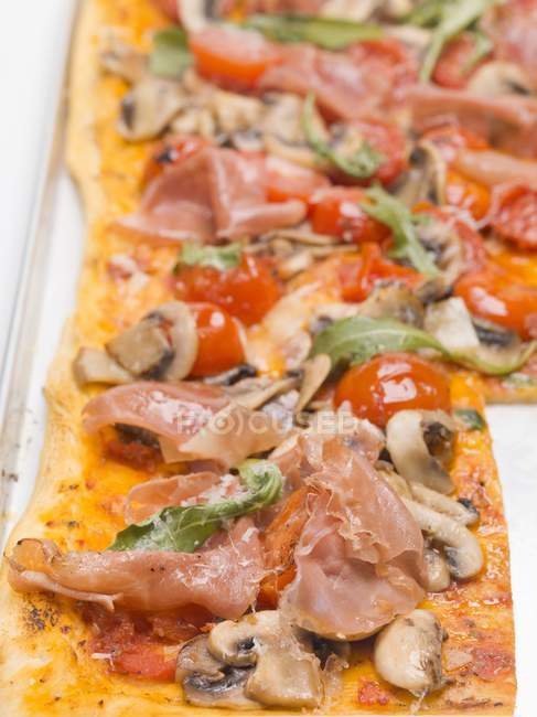 Fetta di pizza condita con prosciutto — Foto stock