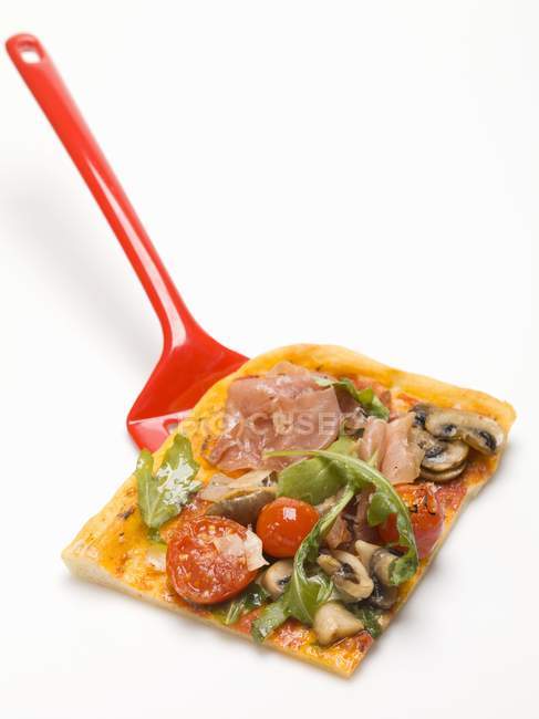 Rebanada de pizza cubierta con jamón - foto de stock