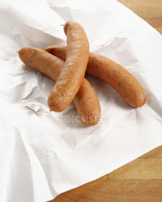 Cheese-stuffed sausages on paper — Stock Photo