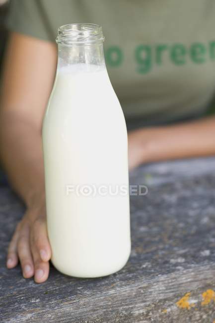 Kid holding bottle of organic milk — Stock Photo