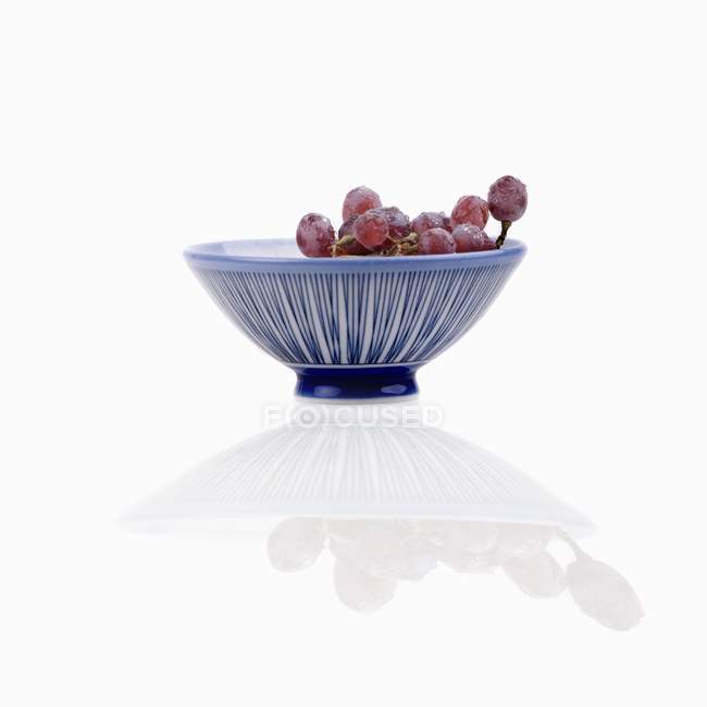 Червоний виноград у смугастій мисці — стокове фото