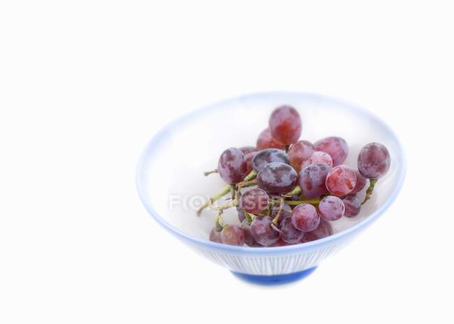 Красный виноград в полосатой чаше — стоковое фото