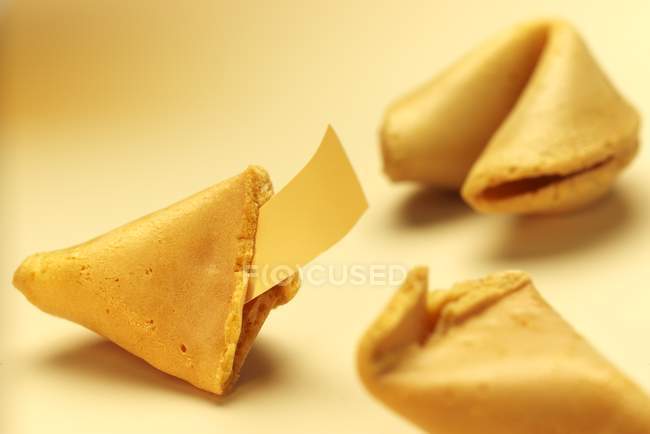 Closeup view of three fortune cookies with paper in one — Stock Photo