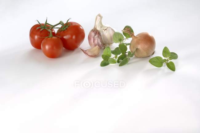 Tomatoes with garlic and marjoram — Stock Photo
