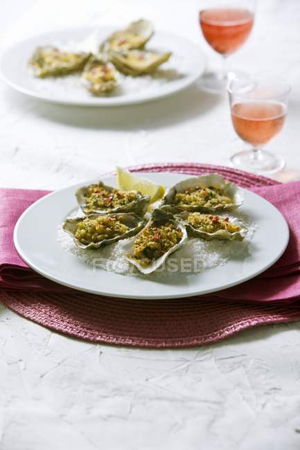 Ostriche gratinate in piatto bianco — Foto stock