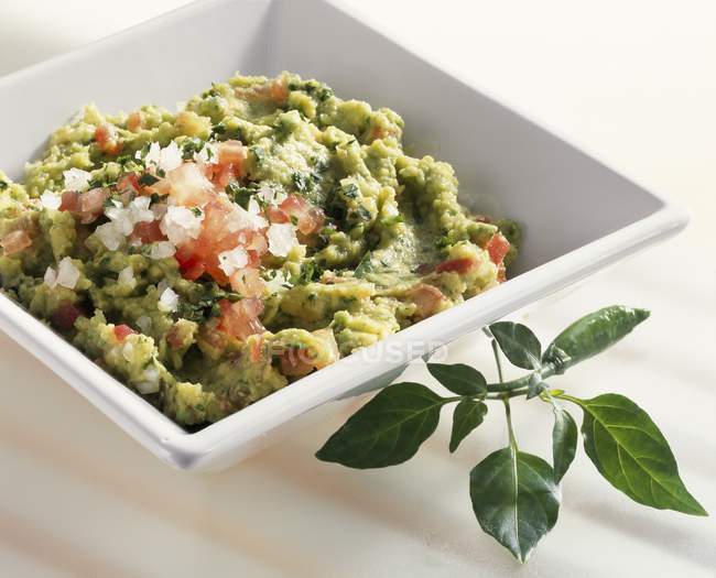 Guacamole in a dish on white surface — Stock Photo