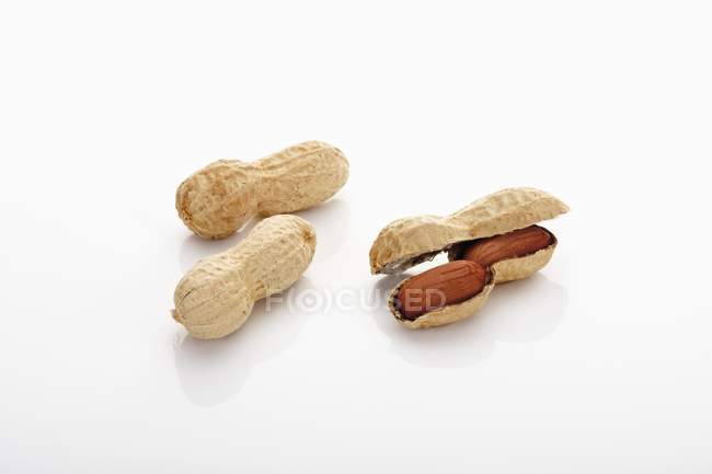 Tres cacahuetes sobre fondo blanco - foto de stock