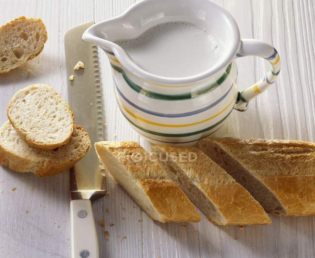 Jug of milk with baguette — Stock Photo