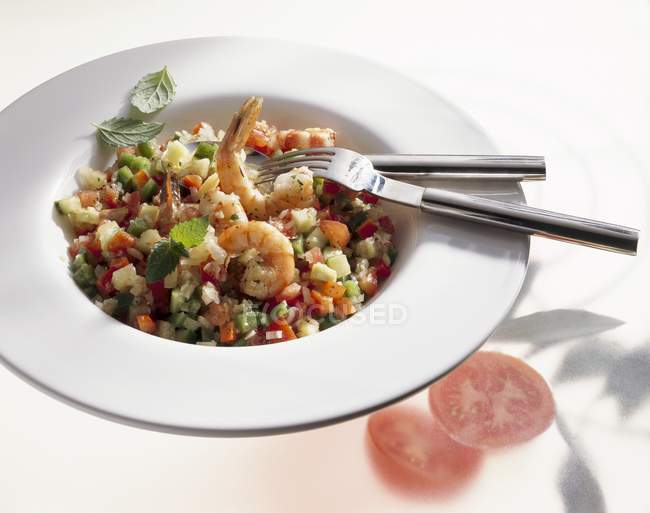 Paprika und Tomatensalat mit Garnelen auf weißem Teller mit Gabel und Messer — Stockfoto