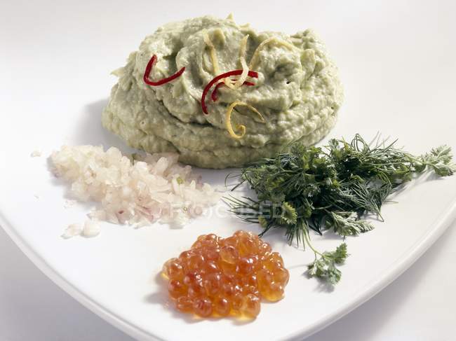 Avocado-Püree mit Kräutern, Schalotten und Forellen-Kaviar auf weißem Teller — Stockfoto