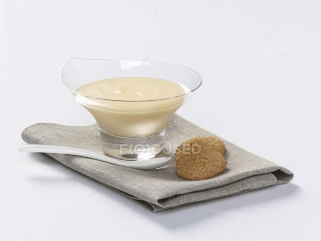 Closeup view of vanilla cream in glass bowl and two cookies — Stock Photo